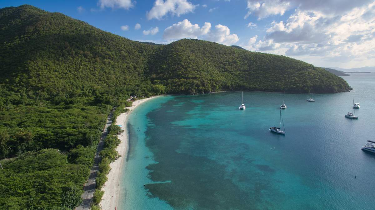 Aerial view of multiple charter boats and sailboats anchored in the turquoise waters around St. John USVI