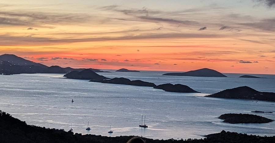 Panoramic view of St. John's lush green mountains and valleys with blue ocean waters in the distance
